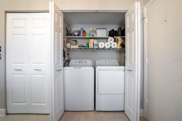 laundry room featuring washing machine and dryer and light tile patterned floors