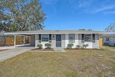 ranch-style home with a carport and a front lawn