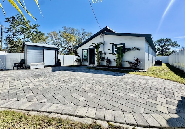 exterior space with a patio, central AC, and a storage unit