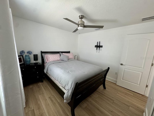 bedroom with light hardwood / wood-style flooring and ceiling fan