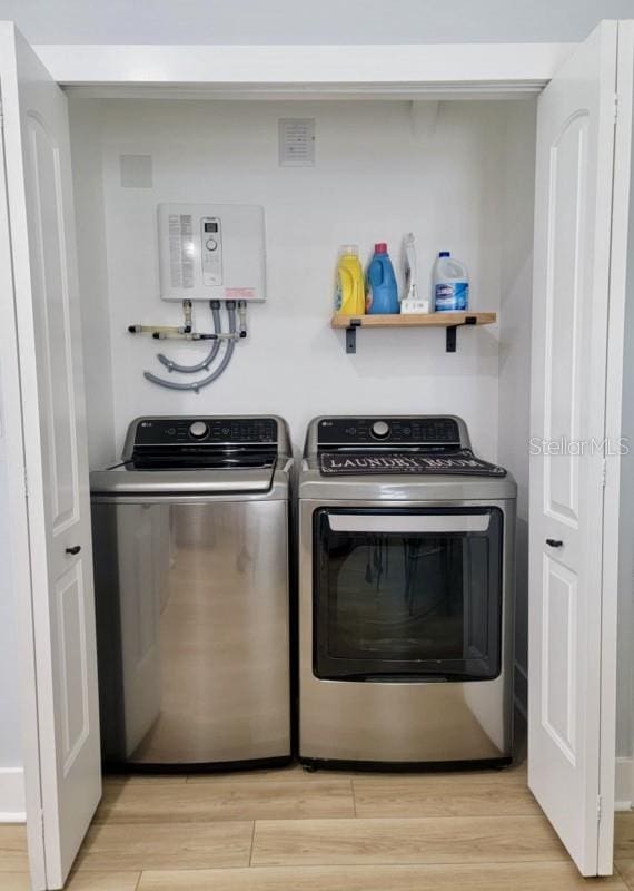 laundry room with washer and dryer and light hardwood / wood-style floors