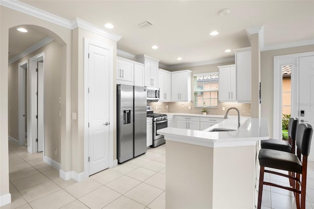 kitchen featuring white cabinetry, appliances with stainless steel finishes, crown molding, and sink