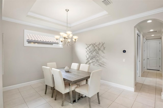 dining space with crown molding, light tile patterned flooring, and a tray ceiling