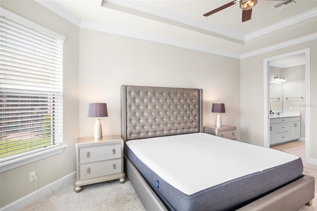 bedroom with connected bathroom, light colored carpet, a raised ceiling, and ceiling fan