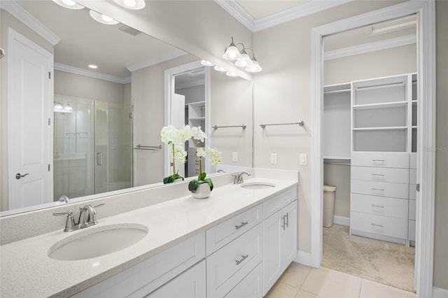 bathroom with a shower with door, vanity, tile patterned floors, and crown molding