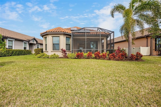 back of property with a yard and a lanai