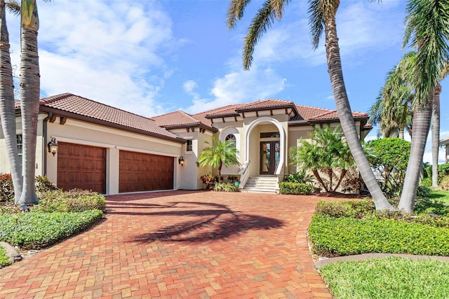 mediterranean / spanish home with a garage and french doors