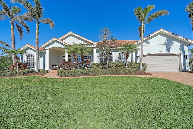 view of front of home with a garage and a front lawn