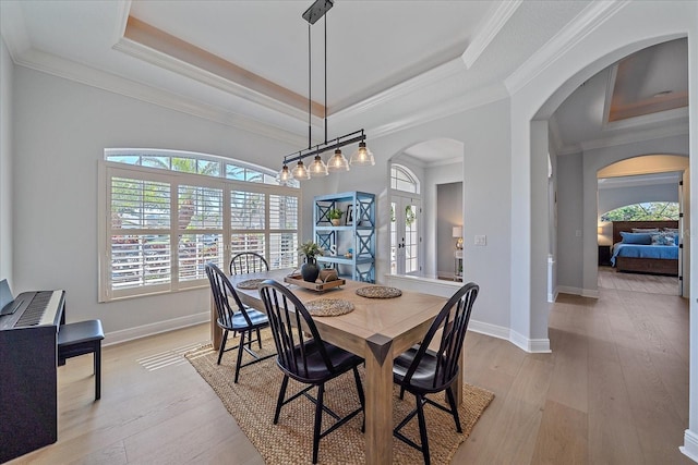 dining room with french doors, light hardwood / wood-style flooring, and a tray ceiling