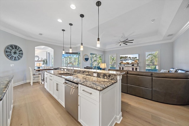 kitchen featuring sink, decorative light fixtures, dishwasher, dark stone counters, and white cabinets