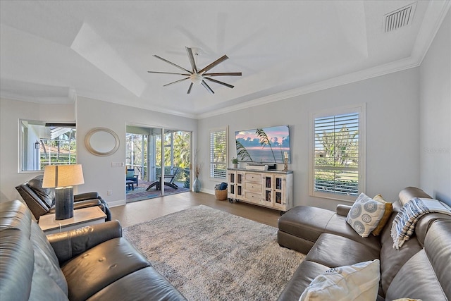 living room with hardwood / wood-style floors, a wealth of natural light, ornamental molding, and ceiling fan