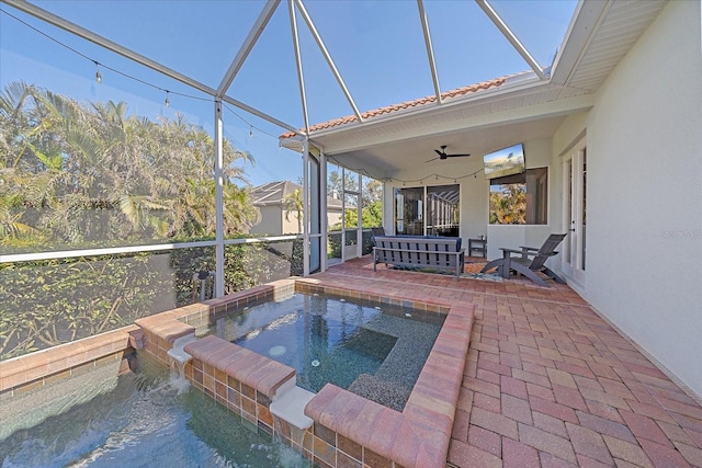 view of pool with ceiling fan, glass enclosure, a patio area, pool water feature, and an in ground hot tub