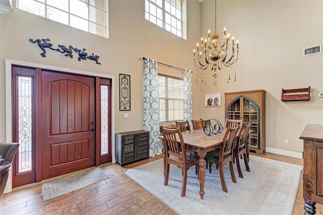 dining room with light hardwood / wood-style floors and a notable chandelier