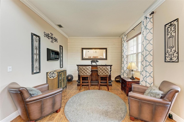 living area featuring hardwood / wood-style floors and ornamental molding