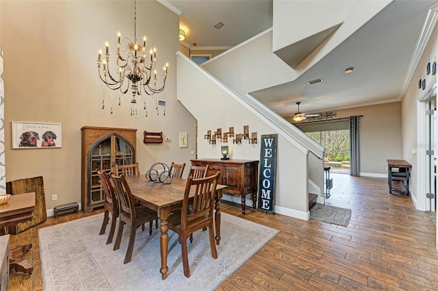 dining area featuring ornamental molding, dark wood-type flooring, and ceiling fan with notable chandelier