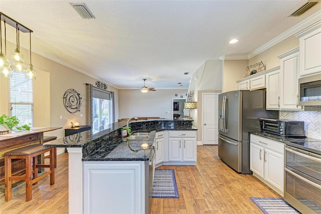 kitchen featuring white cabinetry, appliances with stainless steel finishes, sink, and light hardwood / wood-style flooring