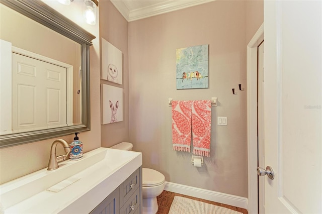 bathroom with vanity, ornamental molding, and toilet