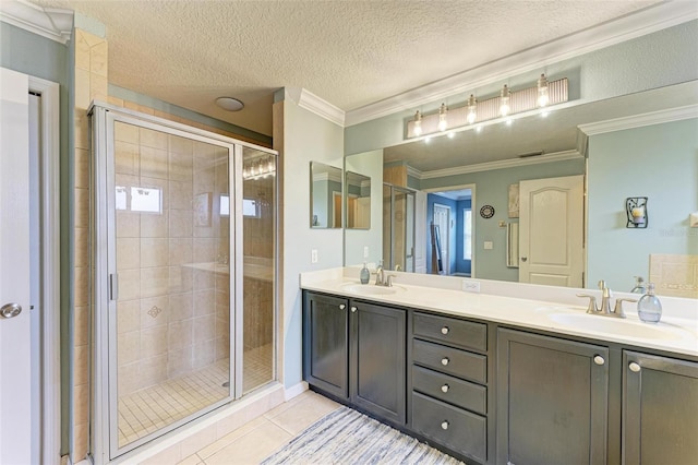 bathroom featuring tile patterned floors, a shower with shower door, crown molding, a textured ceiling, and vanity