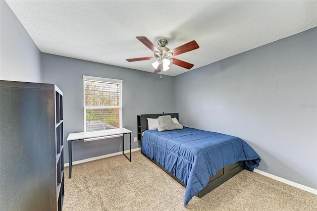 bedroom with ceiling fan, light colored carpet, and a textured ceiling