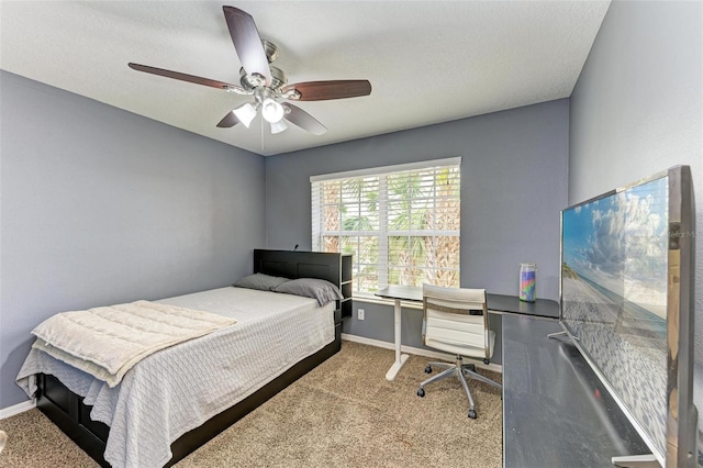 carpeted bedroom featuring ceiling fan and a textured ceiling