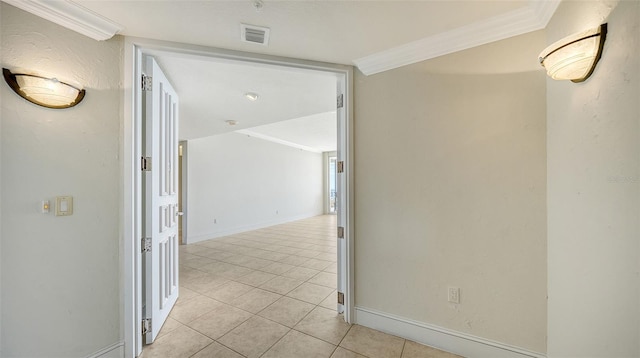 hallway with ornamental molding and light tile patterned floors