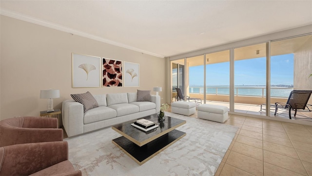 living room with a view of the beach, a water view, light tile patterned floors, ornamental molding, and expansive windows