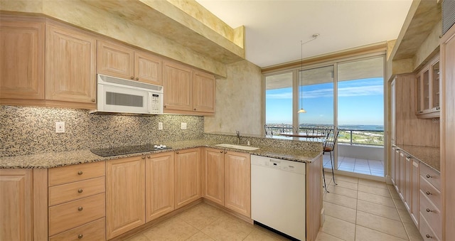 kitchen featuring light stone counters, white appliances, kitchen peninsula, and light brown cabinets