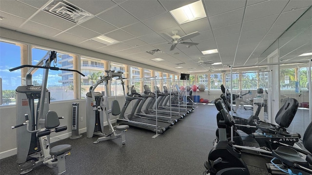 exercise room featuring a paneled ceiling, a wealth of natural light, and ceiling fan