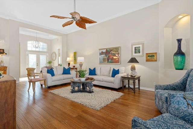 living room featuring wood-type flooring, ornamental molding, ceiling fan, and french doors