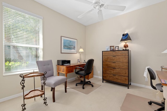 carpeted home office with ceiling fan and a healthy amount of sunlight