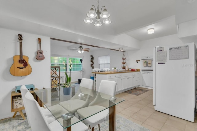 tiled dining room featuring sink and ceiling fan with notable chandelier