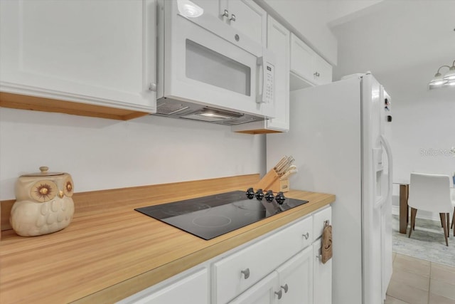 kitchen with light tile patterned floors, white cabinets, and black electric cooktop