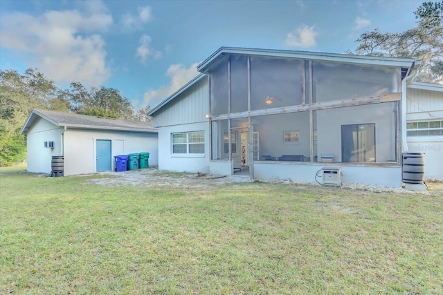 back of property featuring a sunroom, cooling unit, and a lawn