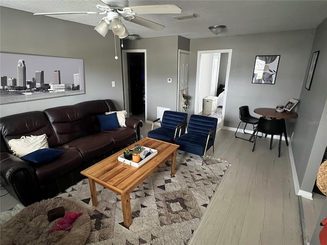 living room with light hardwood / wood-style flooring and ceiling fan