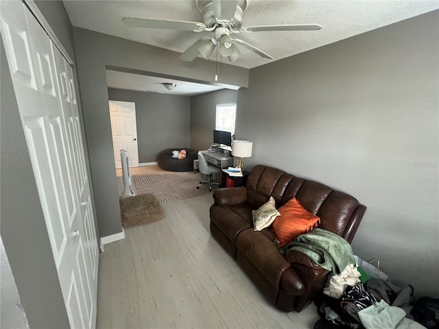 living room featuring ceiling fan and light wood-type flooring