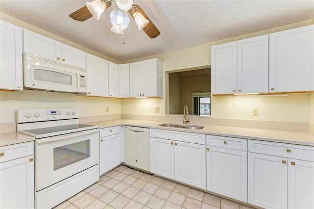 kitchen featuring sink, a textured ceiling, white cabinets, and white appliances