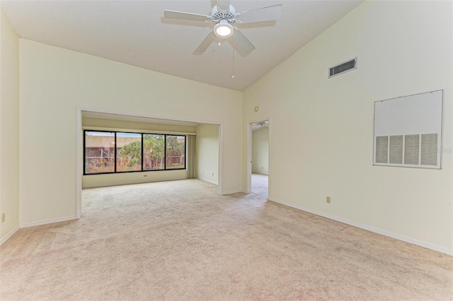 carpeted spare room with ceiling fan and high vaulted ceiling