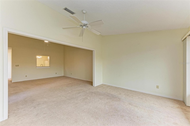 unfurnished room featuring light colored carpet, a textured ceiling, and ceiling fan