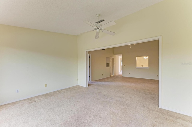 spare room with ceiling fan, light colored carpet, high vaulted ceiling, and a textured ceiling