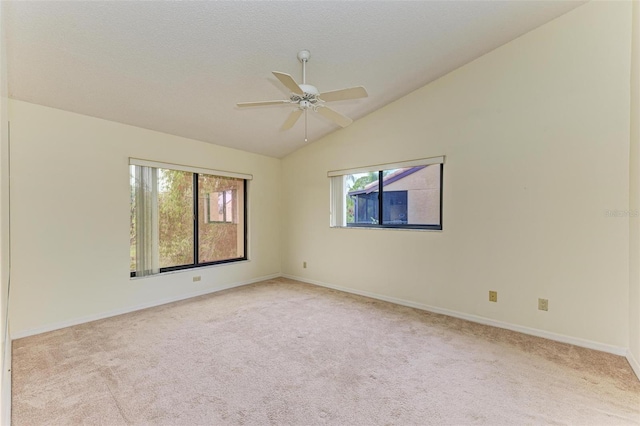 carpeted empty room featuring vaulted ceiling, a wealth of natural light, ceiling fan, and a textured ceiling