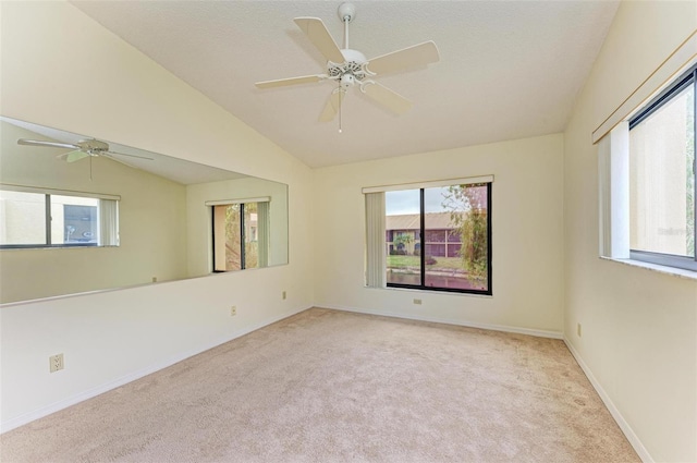 unfurnished room with lofted ceiling, light colored carpet, and ceiling fan