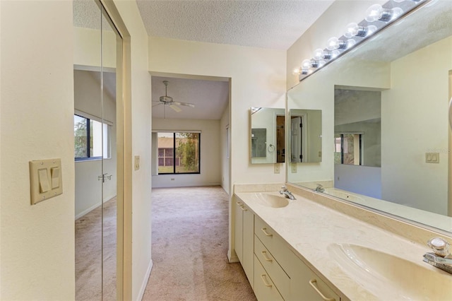 bathroom featuring ceiling fan, vanity, and a textured ceiling