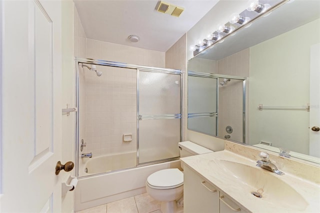 full bathroom with shower / bath combination with glass door, tile patterned floors, toilet, and vanity