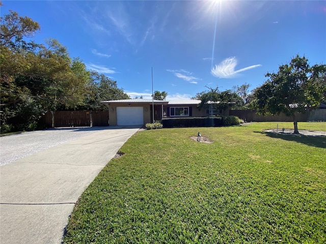 single story home featuring a garage and a front yard