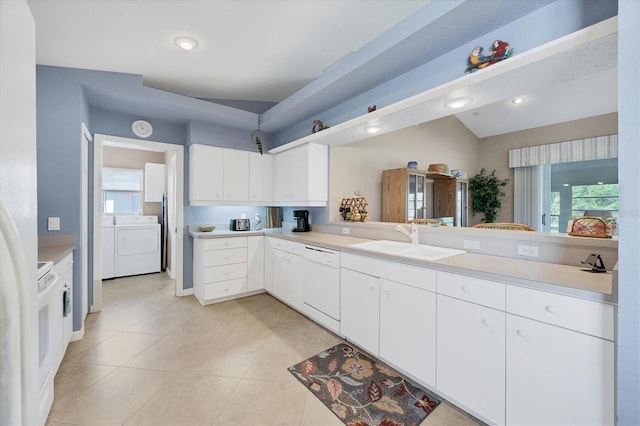 kitchen with sink, light tile patterned floors, washer and clothes dryer, dishwasher, and white cabinetry