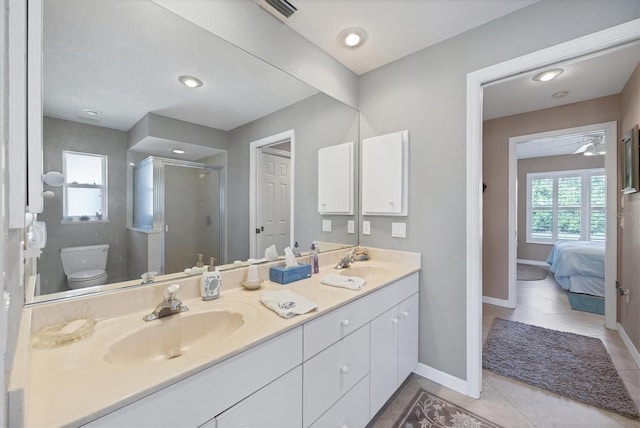 bathroom featuring tile patterned flooring, vanity, toilet, and walk in shower