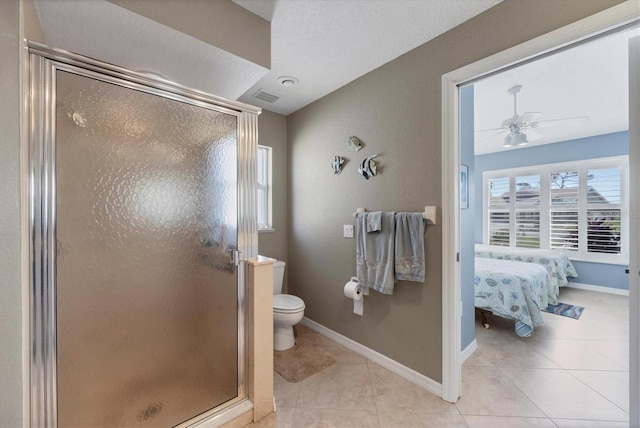 bathroom with ceiling fan, tile patterned floors, toilet, and walk in shower