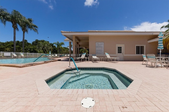 view of pool featuring a community hot tub and a patio