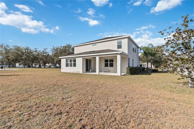 rear view of house featuring a patio area and a lawn