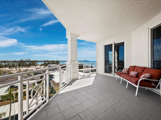 balcony with a water view and an outdoor hangout area